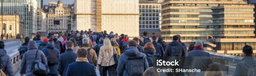 Crowds of commuters on London Bridge rushing into the City offices during sunrise