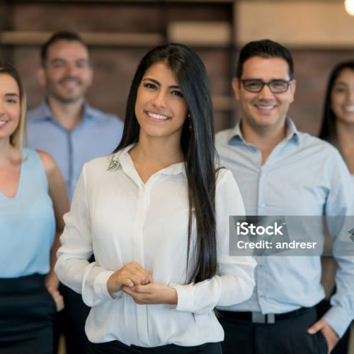 Happy group of business people working at the office and looking at the camera smiling